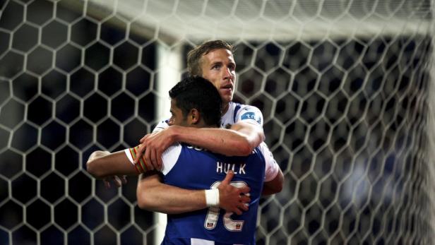 Zwei Fußballspieler umarmen sich vor einem Tornetz.