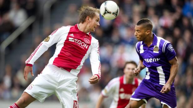 Zwei Fußballspieler kämpfen um den Ball während eines Spiels.