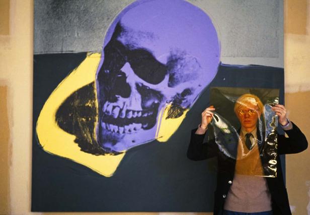 Andy Warhol steht vor seinem Werk „Skull“.