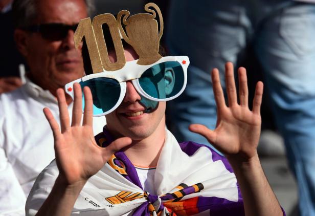 Ein Fan mit einer Schärpe und einer lustigen Brille feiert ein Sportereignis.