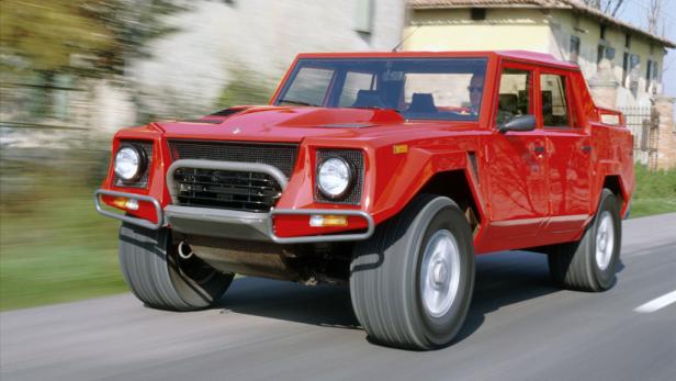 Ein roter Lamborghini LM002 fährt auf einer asphaltierten Straße.