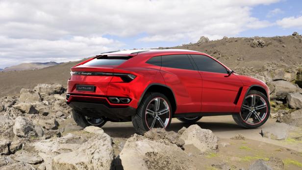 Ein roter Lamborghini Urus steht auf einem felsigen Untergrund.