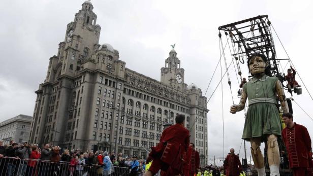 Eine riesige Marionette in Liverpool wird von mehreren Personen geführt.