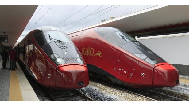 Zwei rote Hochgeschwindigkeitszüge der Marke Italo stehen an einem Bahnsteig.