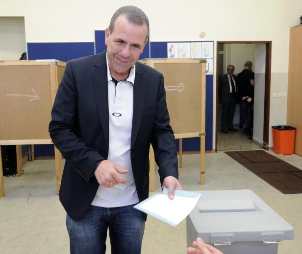 Ein Mann wirft einen Wahlzettel in eine Wahlurne.