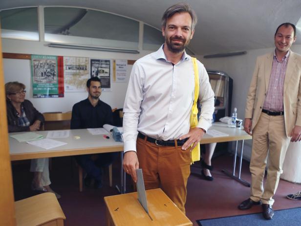 Ein Mann wirft einen Stimmzettel in eine Wahlurne.