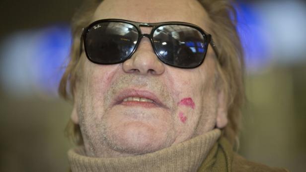 Ein Mann mit Sonnenbrille und einem Kussabdruck auf der Wange.