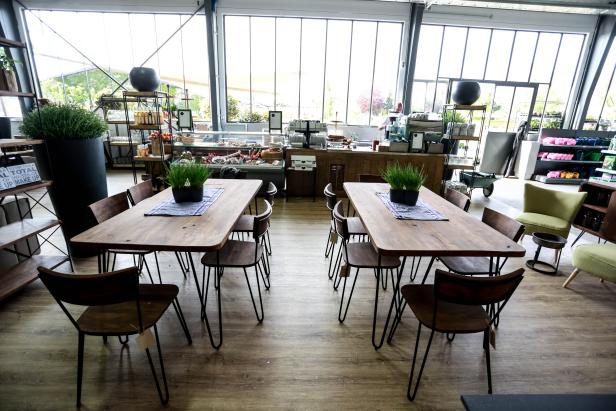 Einrichtung mit Holztischen und Stühlen in einem hellen Raum.