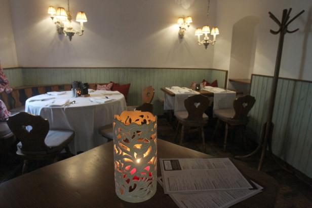 Ein beleuchtetes Windlicht steht auf einem Tisch in einem Restaurant.