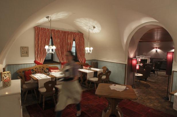 Ein Restaurantraum mit gedeckten Tischen und einer unscharfen Kellnerin im Vordergrund.