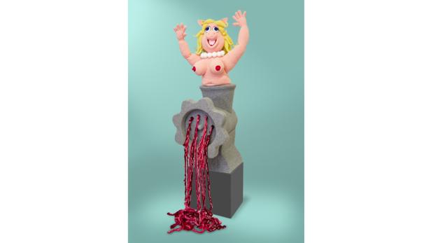 Eine Skulptur von Miss Piggy, die aus einem Fleischwolf kommt, aus dem rote Fäden quellen.