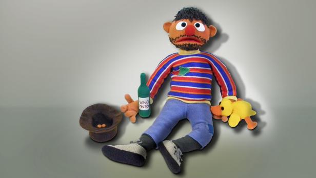 Eine Stoffpuppe mit einer Flasche „Vino Tinto“ und einem gelben Entchen.