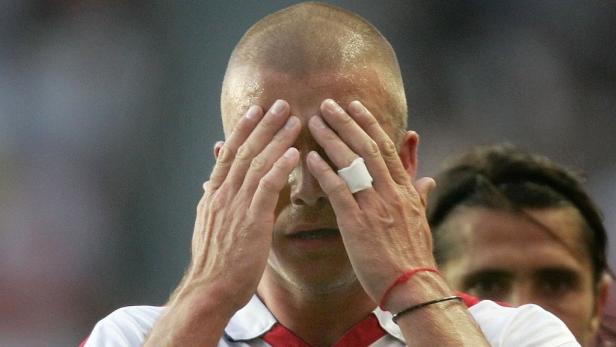 Ein Mann mit einem Verband am Finger hält die Hände vors Gesicht.