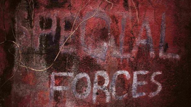 Die Worte „Special Forces“ sind auf eine rote, verwitterte Wand gesprüht.