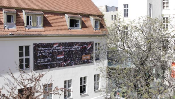 An der Fassade eines Gebäudes hängt ein Banner mit der Aufschrift „Das ägyptische Volk verdient den Friedensnobelpreis“.