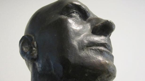 Nahaufnahme einer Bronzebüste, die ein nach oben gerichtetes Gesicht zeigt.