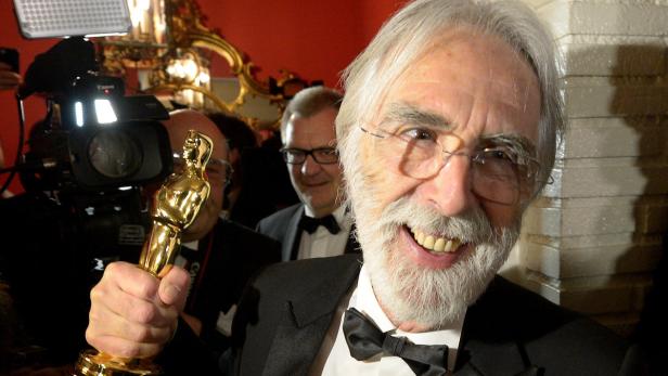 Ein Mann mit Bart und Brille hält eine goldene Oscar-Statue in der Hand.