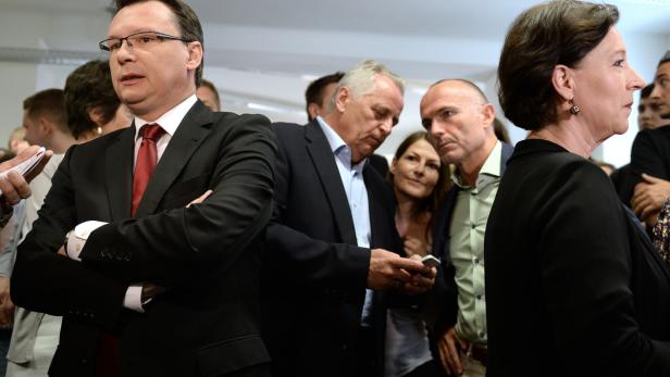 Eine Gruppe von Menschen steht beieinander, einige in Anzügen.