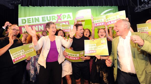 Politiker und Unterstützer feiern mit Schildern „Europa wird grüner! Danke!“.