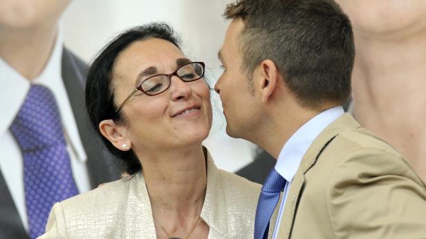 Ein Mann gibt einer Frau mit Brille einen Kuss auf die Wange.