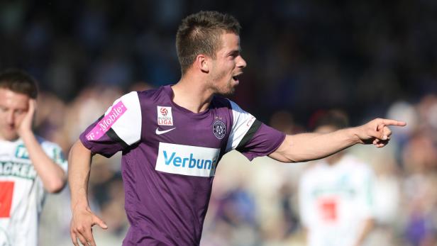 Ein Fußballspieler in lila Trikot gestikuliert auf dem Spielfeld.