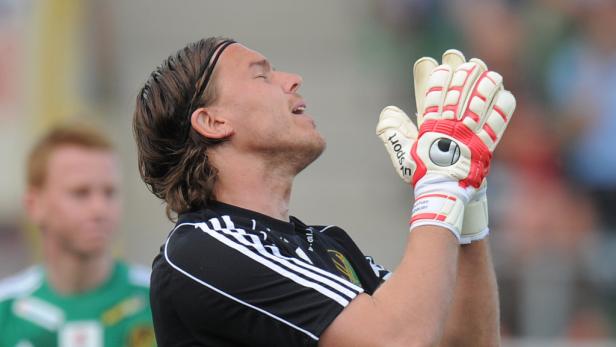 Ein Torwart mit Handschuhen blickt erwartungsvoll nach oben.