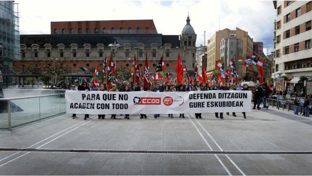 Eine Demonstration mit vielen Menschen und Flaggen in einer Stadt.