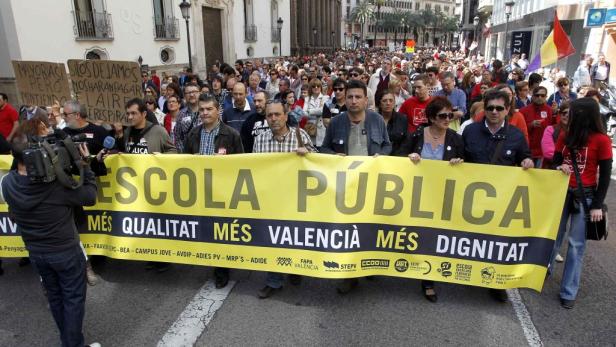 Eine Demonstration mit einem gelben Banner „Escola Pública: Més Qualitat, Més Valencià, Més Dignitat“.