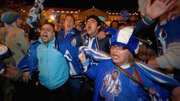Eine Gruppe jubelnder Fußballfans des FC Porto feiert auf der Straße.