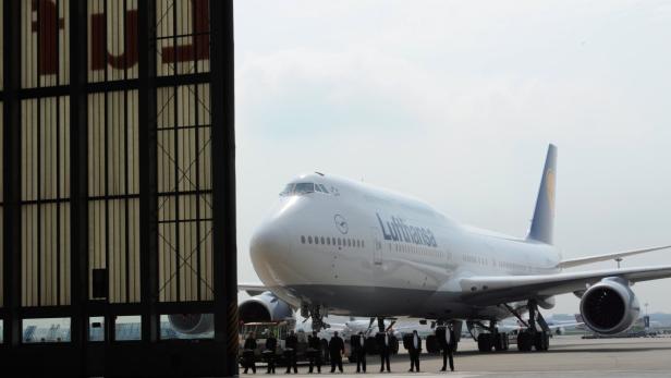 Eine Boeing 747 der Lufthansa steht auf dem Rollfeld vor einem Hangar.
