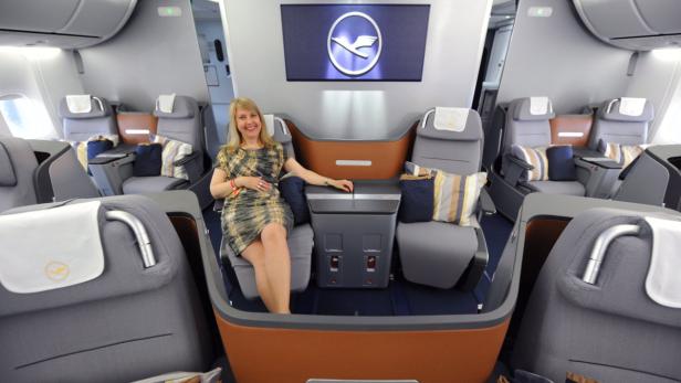 Eine Frau sitzt in der Business Class eines Lufthansa-Flugzeugs.