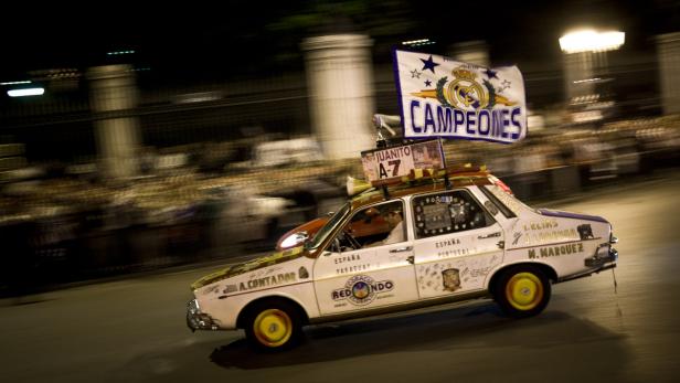 Ein dekoriertes Auto mit einer „Campeones“-Flagge fährt durch die Nacht.