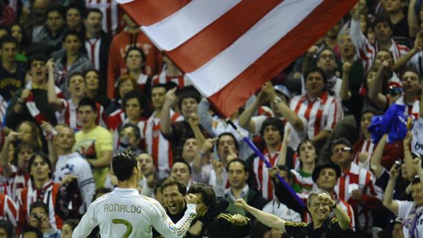 Cristiano Ronaldo vor einer jubelnden Menge im rot-weiß gestreiften Trikot.