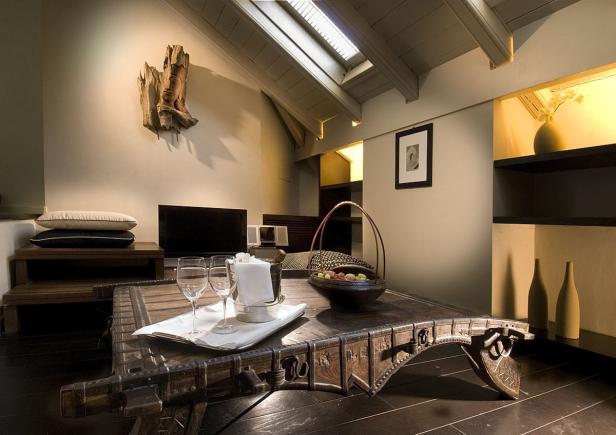 Ein Wohnzimmer mit einem verzierten Holztisch und dekorativen Elementen.