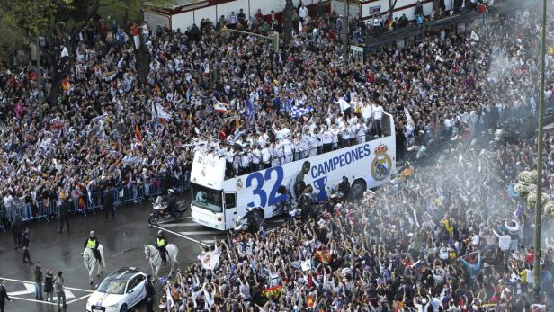 Eine Menschenmenge feiert mit dem Real Madrid-Team auf einem offenen Bus.