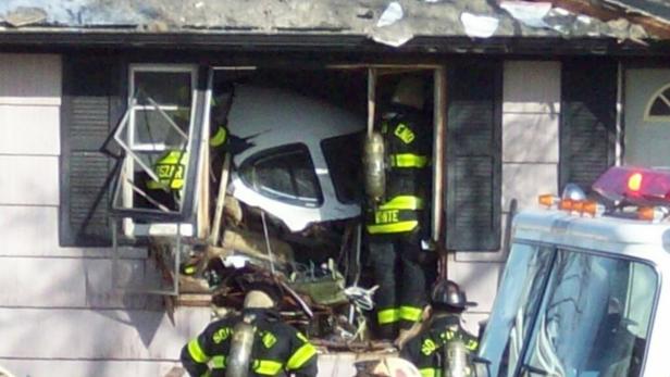 Ein Auto ist in die Wand eines Hauses gekracht, Feuerwehrleute sind vor Ort.