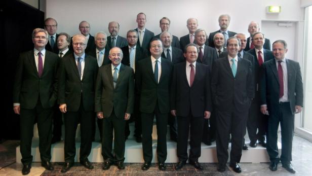 Eine formelle Gruppenaufnahme von etwa zwanzig Männern in Anzügen.