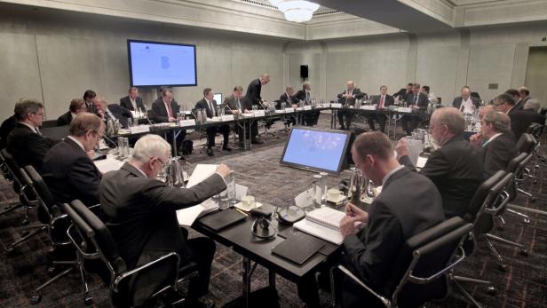 Eine Gruppe von Menschen sitzt in einem Konferenzraum an einem Tisch.