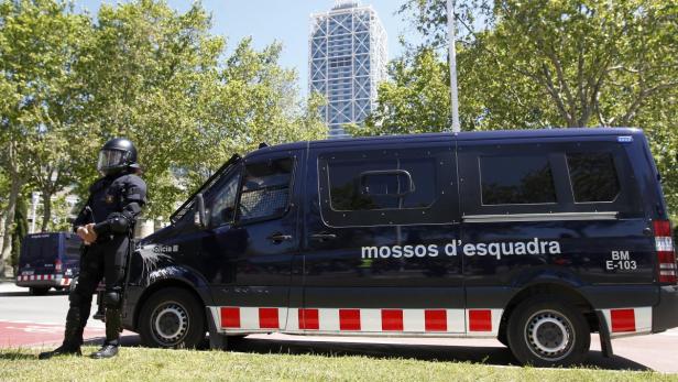 Ein Polizist der Mossos d'Esquadra steht neben einem Einsatzwagen in Barcelona.