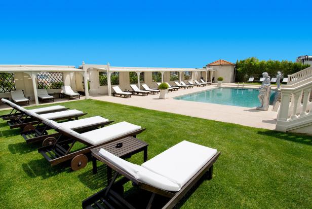 Ein Swimmingpool mit Liegestühlen auf einer gepflegten Rasenfläche.