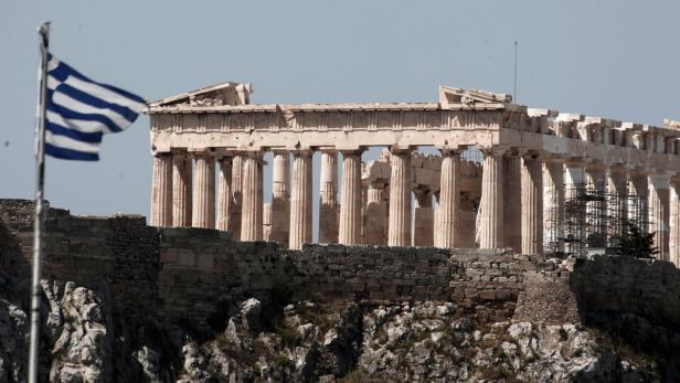 Die griechische Flagge weht vor dem Parthenon in Athen.