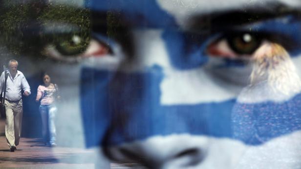 Ein Mann und eine Frau gehen auf dem Bürgersteig, überlagert von einem Gesicht in den Farben der griechischen Flagge.