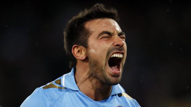 Ein Mann in einem hellblauen Trikot schreit mit weit geöffnetem Mund.