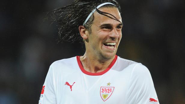 Ein lächelnder Fußballspieler des VfB Stuttgart mit weißem Stirnband.