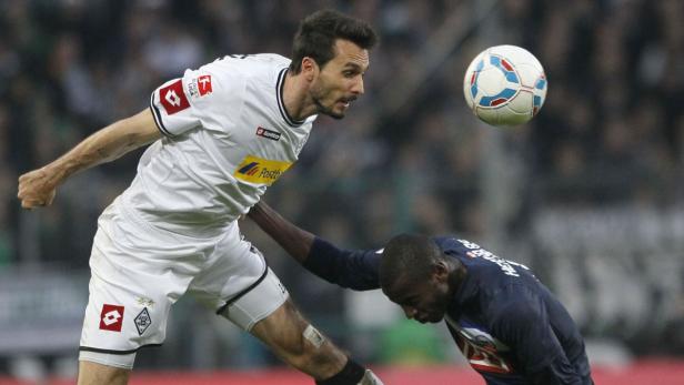 Zwei Fußballspieler kämpfen um den Ball während eines Spiels.