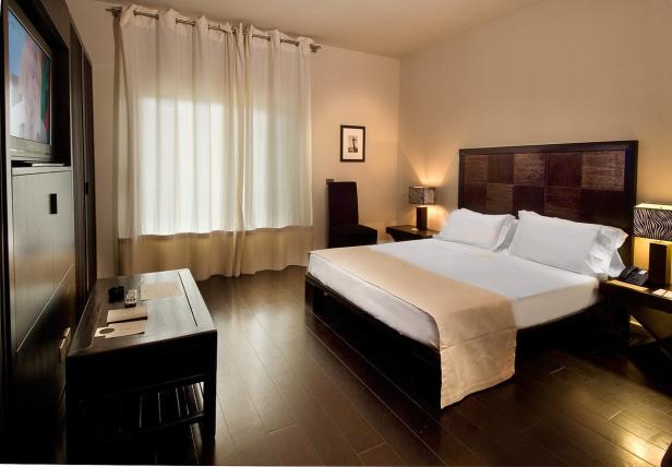 Ein Hotelzimmer mit einem Doppelbett und dunklen Holzmöbeln.