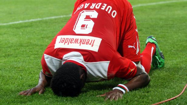 Ein Fußballspieler kniet auf dem Rasen, das Trikot mit der Nummer 6 und dem Namen Ouedraogo tragend.