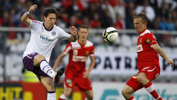 Zwei Fußballspieler kämpfen um den Ball während eines Spiels.