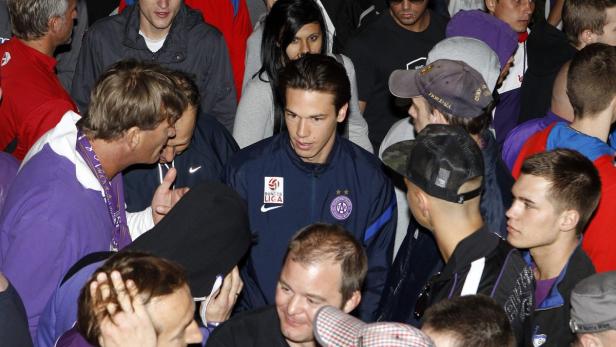 Ein Fußballspieler des FK Austria Wien umringt von Fans.