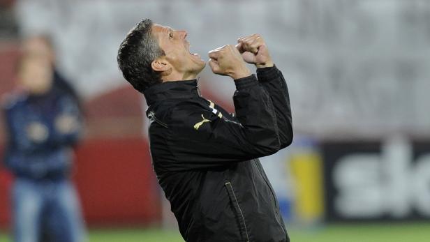 Ein Mann in einer schwarzen Jacke jubelt mit geballten Fäusten.